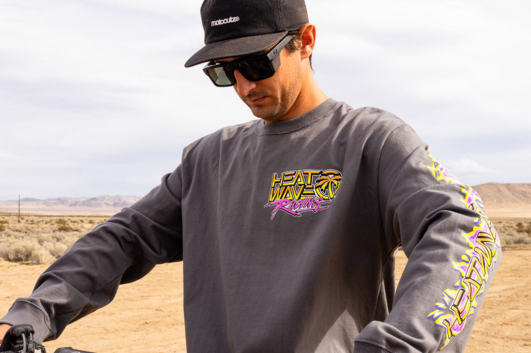 Man in the desert wearing the Heat Wave "Sorry Babe" LONG SLEEVE T-Shirt standing in a desert landscape.