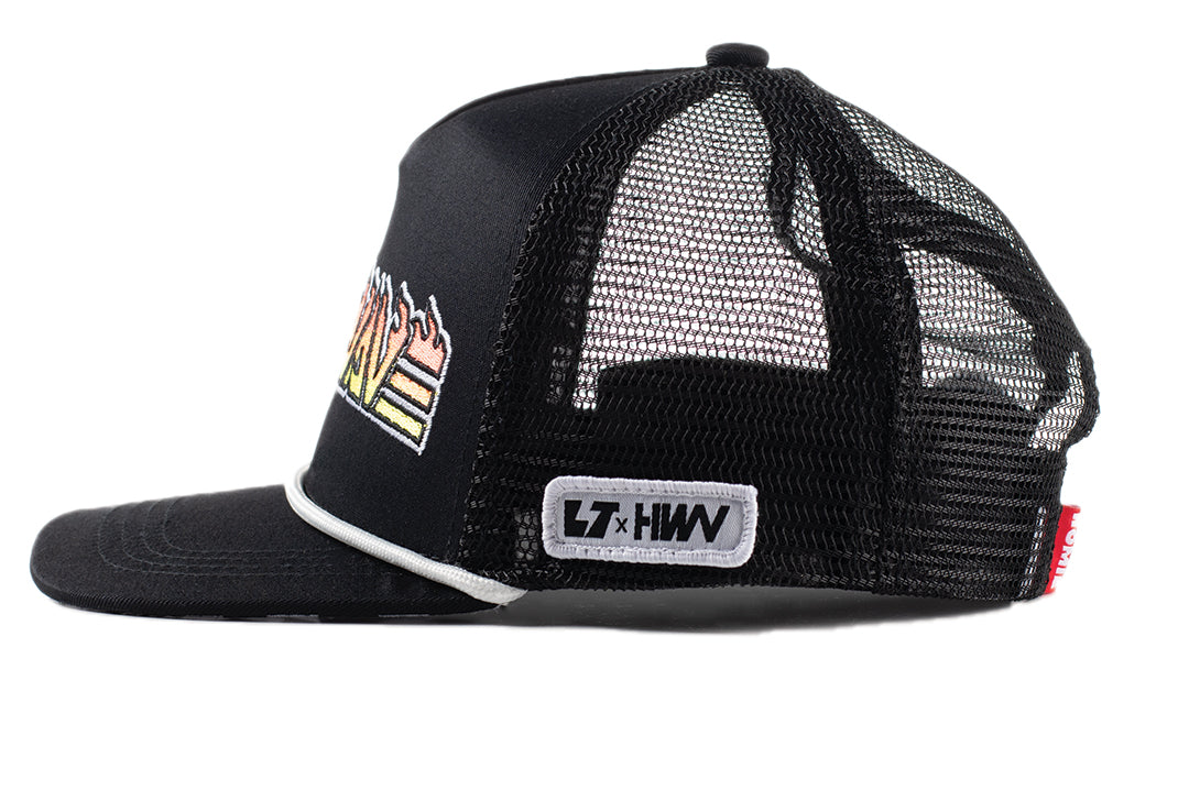 Sideview shot of the Little Trouble X Heat Wave Youth Trucker Hat on a white background. 